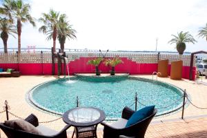 a large swimming pool with chairs and a table at Hamanako Bentenjima Resort The Ocean in Hamamatsu