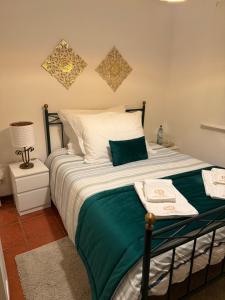 ペーゾ・ダ・レーグアにあるQuinta de São Domingos houseのベッドルーム1室(緑と白のシーツが備わるベッド1台付)