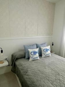 a bed with blue and white pillows on it at Apartamento Grumete in Cotillo