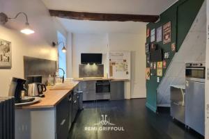a large kitchen with a counter and appliances in it at Kinta Panda Pool Table City Center 13 2 guests in Honfleur +10 photos