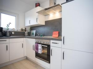 Una cocina con gabinetes blancos y un horno. en Welcome in - vakantiewoningen in Winterberg met panoramisch uitzicht, en Winterberg