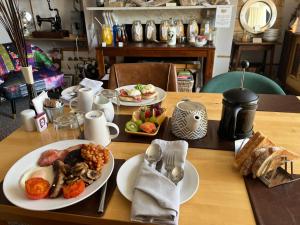 a wooden table with plates of food on it at Kelston Guest House in Weymouth