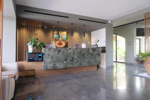 a lobby with a reception desk with a woman wearing sunglasses at Limen Wellness Hotel & Spa in Campofelice di Roccella +71 photos