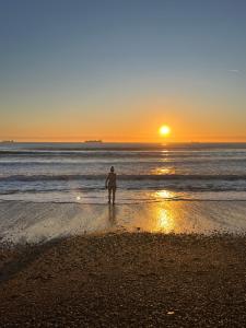 a person standing on the beach watching the sunset at Kelston Guest House in Weymouth