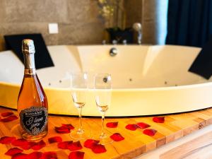 a bottle of champagne and two glasses on a table with a bath tub at Time Out 3 in Vreden