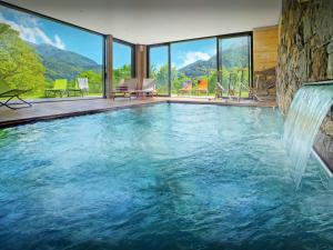 a swimming pool with a waterfall in a house at Lodge La Source - OVO Network in Les Clefs