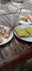 Tongwe Cultural Heritage Center في Katumbi: ثلاثة أطباق من الطعام على طاولة خشبية