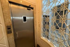 a metal door in a hallway with a window at Incrível Apartamento ao lado Copacabana Palace in Rio de Janeiro