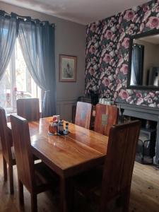 a dining room with a wooden table and chairs at Cherry Blossom House in Bujaleuf