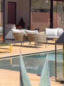 SraghnaにあるVilla à Marrakech 8 Personnes, Piscine et Petits-Déjeuners Inclusのスイミングプール(いくつかの椅子、ソファ付)