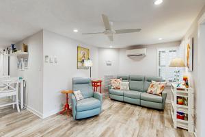 リホボスビーチにあるTown of Rehoboth Beach --- The Boxwood House - 21 Wilmington Ave #1Eのリビングルーム(青い椅子2脚、天井ファン付)