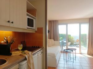 a kitchen and a living room with a couch at T1 Bis avec piscine vue golf et montagnes in Arcangues