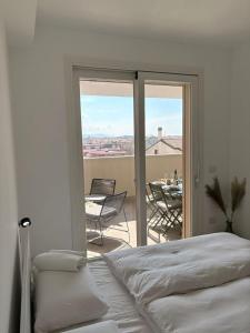a bedroom with a bed and a balcony with a table at Penthouse Apartment A due passi dal Mare in Alghero