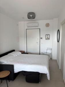 a bedroom with a large white bed and a table at Penthouse Apartment A due passi dal Mare in Alghero