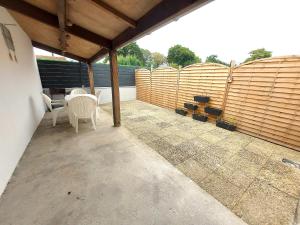 a patio with a table and chairs and a fence at PLAIN PIED, avec mezzanine et espace extérieur 10min Puy du F in Les Herbiers +20 photos