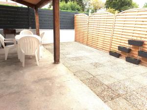a patio with a table and chairs and a fence at PLAIN PIED, avec mezzanine et espace extérieur 10min Puy du F in Les Herbiers