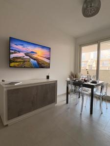 a living room with a table and a television on the wall at Penthouse Apartment A due passi dal Mare in Alghero +33 photos