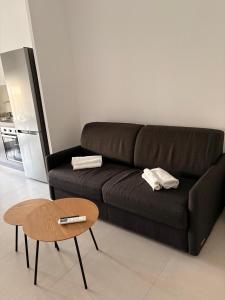 a black couch in a living room with a table at Penthouse Apartment A due passi dal Mare in Alghero