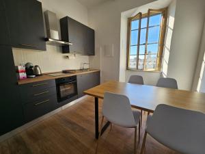 a kitchen with a wooden table and chairs in it at Be Your Home - Stazione Mare in Civitavecchia