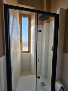 a shower with a glass door in a bathroom at Be Your Home - Stazione Mare in Civitavecchia