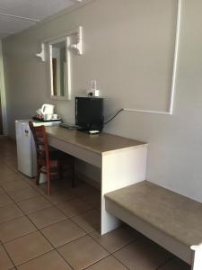 a kitchen with a table and a microwave at Black Nugget Hotel Motel in Moranbah