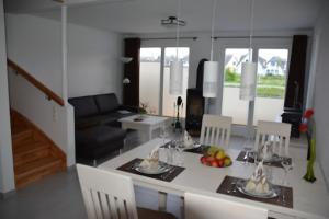 eine Küche und ein Wohnzimmer mit Tisch und Stühlen in der Unterkunft Boddenblick - Breege in Breege