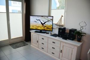 einen Flachbild-TV auf einer Kommode in der Unterkunft Boddenblick - Breege in Breege