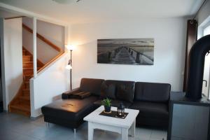 ein Wohnzimmer mit einer Couch und einem Tisch in der Unterkunft Boddenblick - Breege in Breege
