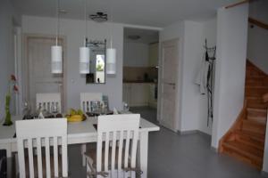eine Küche mit einem weißen Tisch und weißen Stühlen in der Unterkunft Boddenblick - Breege in Breege