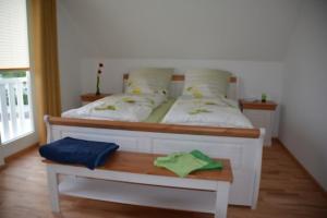Schlafzimmer mit einem Bett und einem Holztisch in der Unterkunft Boddenblick - Breege in Breege