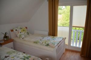 1 Schlafzimmer mit einem Bett und einem Balkon mit einem Fenster in der Unterkunft Boddenblick - Breege in Breege + 23 Fotos