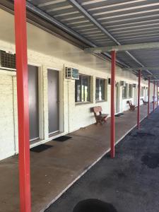 a building with a lot of doors and a bench at Black Nugget Hotel Motel in Moranbah