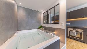a bathroom with a large tub in a kitchen at L'Edelweiss du Lac in Tresserves +35 photos