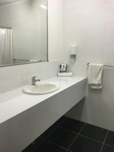 a bathroom with a sink, toilet, and mirror at Black Nugget Hotel Motel in Moranbah