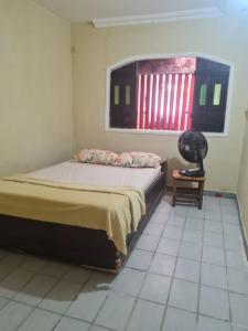 a bedroom with a bed and a window and a table at Casa de praia 5 km de Olinda PE in Paulista