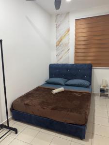 a bed with a blue head board in a room at MelDy Guesthouse Alor Gajah in Kampong Jelatang +20 photos
