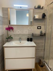 une salle de bains avec un lavabo blanc et un miroir dans l'établissement B&B Tanda Rooms Olbia, à Olbia