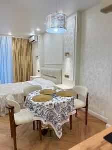 a bedroom with a table and chairs and a bed at NBG d 'amore Appart in Batumi