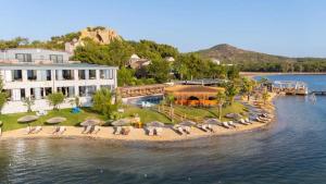 an island in the water with chairs and umbrellas at Ivy Sailing Resort Hotel in Ayvalık
