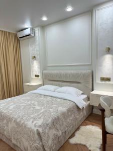 a bedroom with a bed and two tables and a window at NBG d 'amore Appart in Batumi