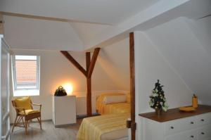 a bedroom with two beds and a table and a chair at Pension AM REICHEN BERG in Moritzburg