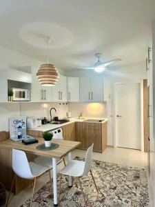 a kitchen with a wooden table and white chairs at Apartamento Grumete in Cotillo