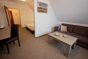 a living room with a couch and a table at Cuxlandhotel Studio 203 in Dorum Neufeld