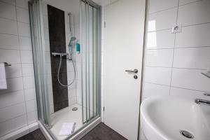 a bathroom with a shower and a sink and a tub at Cuxlandhotel Studio 203 in Dorum Neufeld