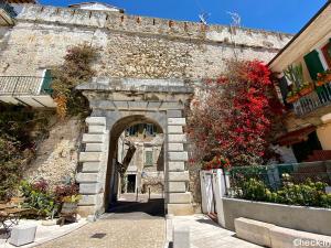 an archway in a stone building with flowers at Le Trifore in Ventimiglia +27 photos