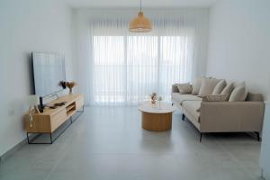 een woonkamer met een bank, een tafel en een tv bij O&O Group Luxury Tower 4BR Panoramic Sea Views in Bat Yam +35 foto's