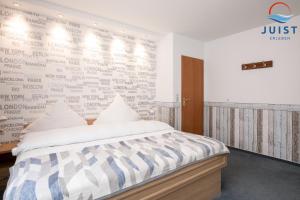 een slaapkamer met een bed en een muur met woorden erop bij Töwerland Zimmer 2 in Juist