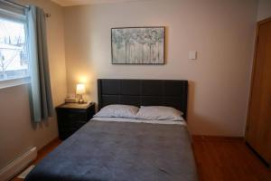 a bedroom with a bed and a picture on the wall at Lynn's Place in Moncton