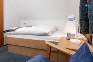 a bedroom with a bed and a table with a lamp at Töwerland Zimmer 6 in Juist