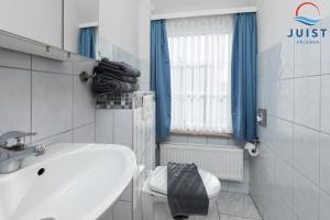 a white bathroom with a sink and a toilet at Töwerland Zimmer 6 in Juist +6 photos